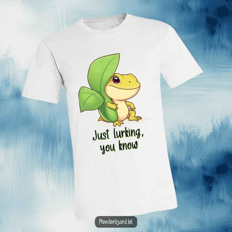 Funny monitor lizard t-shirt featuring a smiling reptile peeking playfully from behind a large, lush green plant, ideal for everyday wear.